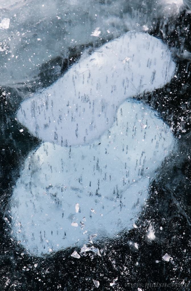 ALX_2698.JPG - Frozen Baikal lake with cracks and bubbles on the transparent ice surface. Winter abstract and blue ice background