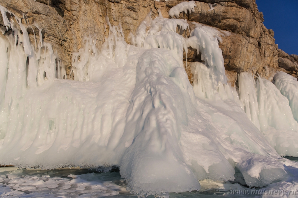 D04B7358.JPG - The rock on the frozen lake Baikal is covered with a thick layer of blue ice: many icicles and splashes