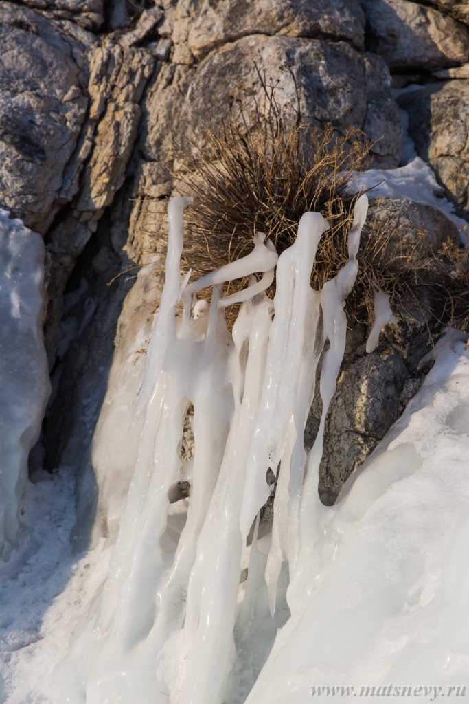 D04B7362.JPG - The rock on the frozen lake Baikal is covered with a thick layer of blue ice: many icicles and splashes