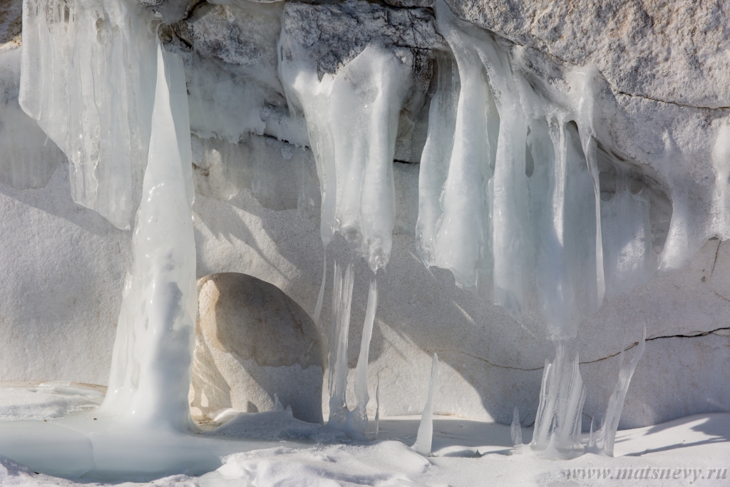 D04B7765.JPG - The rock on the frozen lake Baikal is covered with a thick layer of blue ice: many icicles and splashes