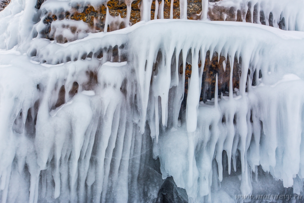 D04B7884-2.JPG - The rock on the frozen lake Baikal is covered with a thick layer of blue ice: many icicles and splashes