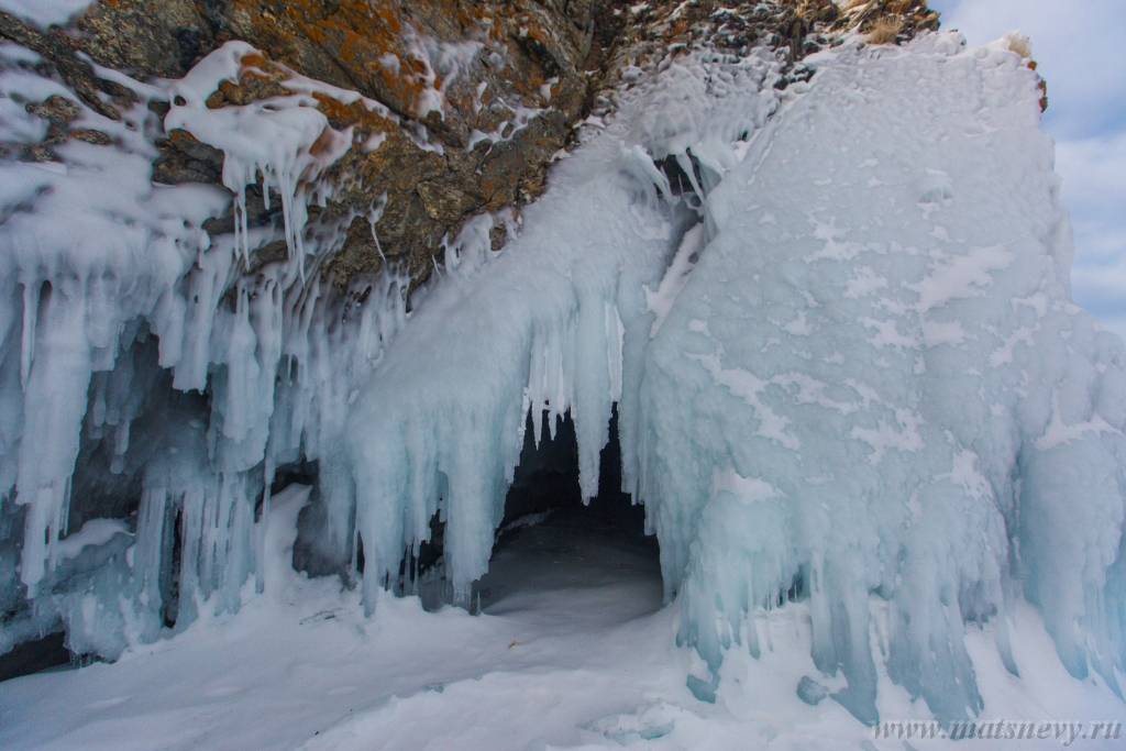 D04B7886.JPG - The rock on the frozen lake Baikal is covered with a thick layer of blue ice: many icicles and splashes