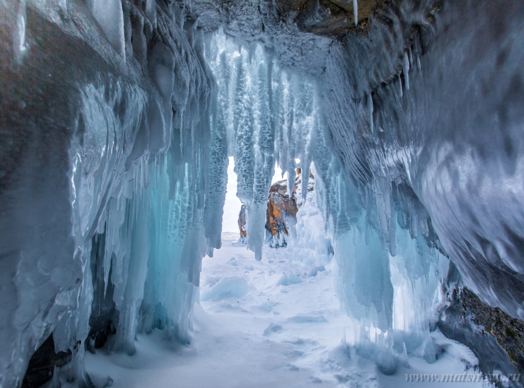 D04B7897.JPG - The rock on the frozen lake Baikal is covered with a thick layer of blue ice: many icicles and splashes