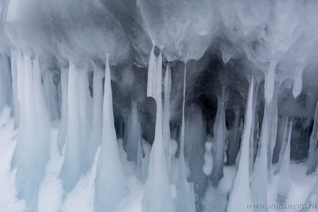 D04B7901.JPG - The rock on the frozen lake Baikal is covered with a thick layer of blue ice: many icicles and splashes
