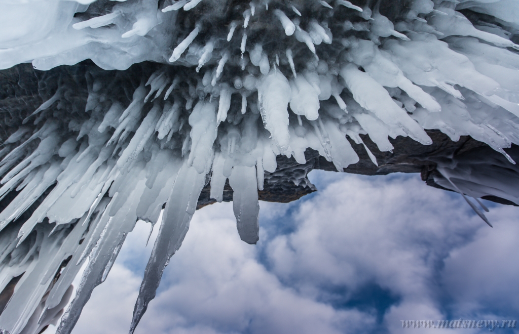 D04B7911.JPG - The rock on the frozen lake Baikal is covered with a thick layer of blue ice: many icicles and splashes