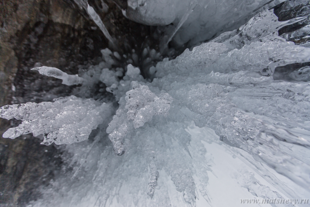 D04B7931.JPG - The rock on the frozen lake Baikal is covered with a thick layer of blue ice: many icicles and splashes