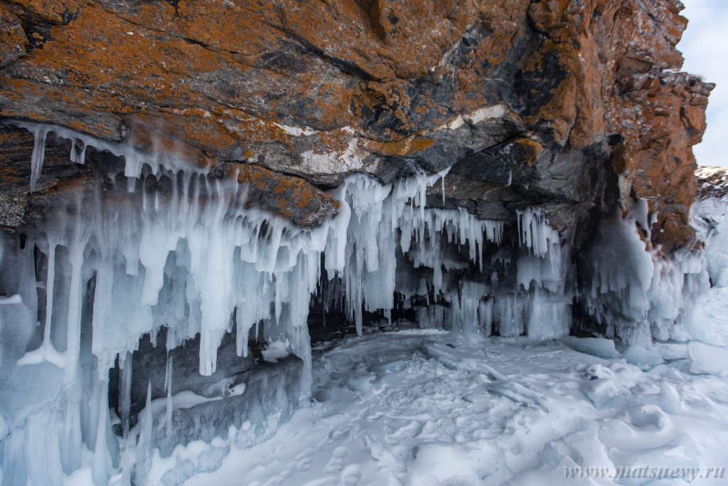 D04B7984.JPG - The rock on the frozen lake Baikal is covered with a thick layer of blue ice: many icicles and splashes