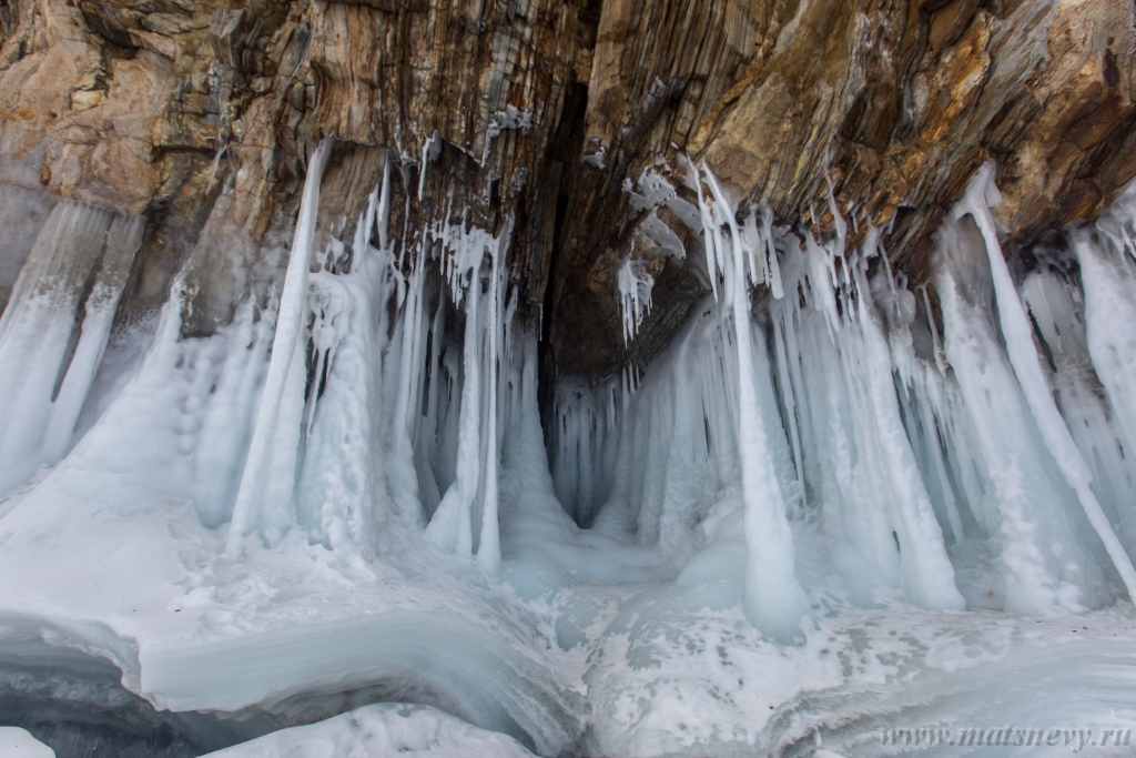 D04B8821.JPG - The rock on the frozen lake Baikal is covered with a thick layer of blue ice: many icicles and splashes