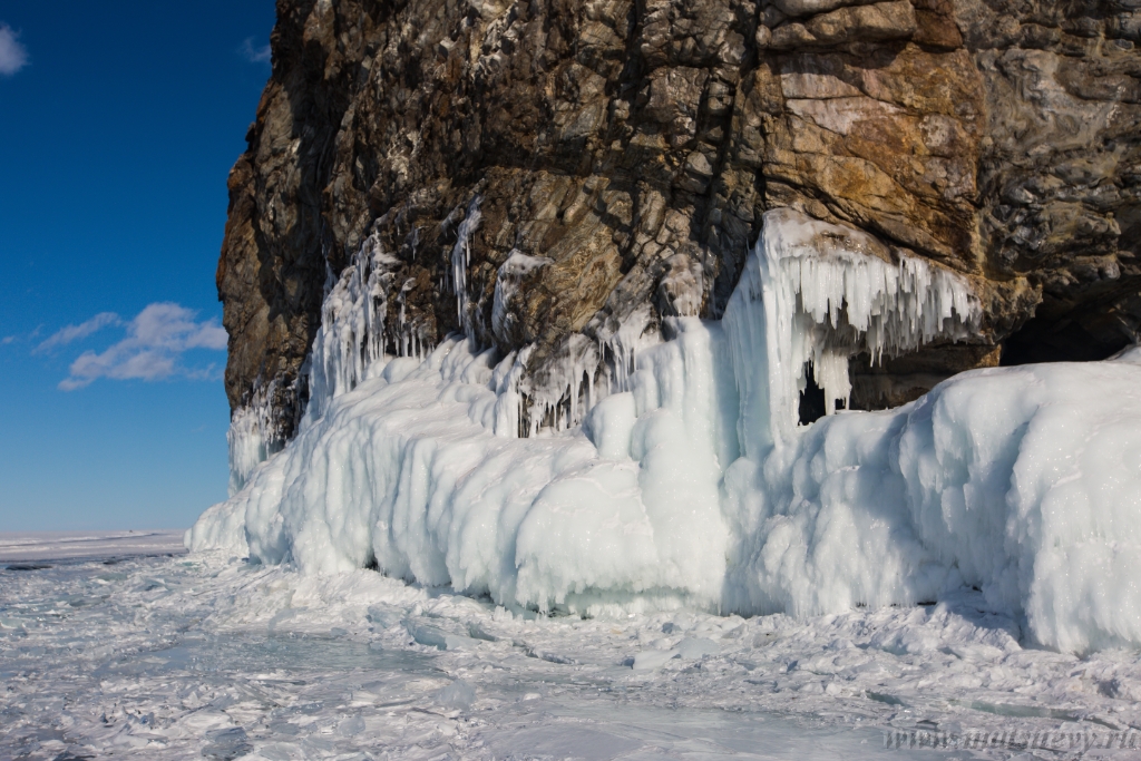 D04B8965.JPG - The rock on the frozen lake Baikal is covered with a thick layer of blue ice: many icicles and splashes