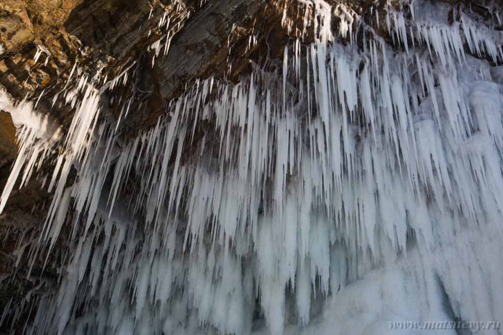 D04B8972.JPG - The rock on the frozen lake Baikal is covered with a thick layer of blue ice: many icicles and splashes