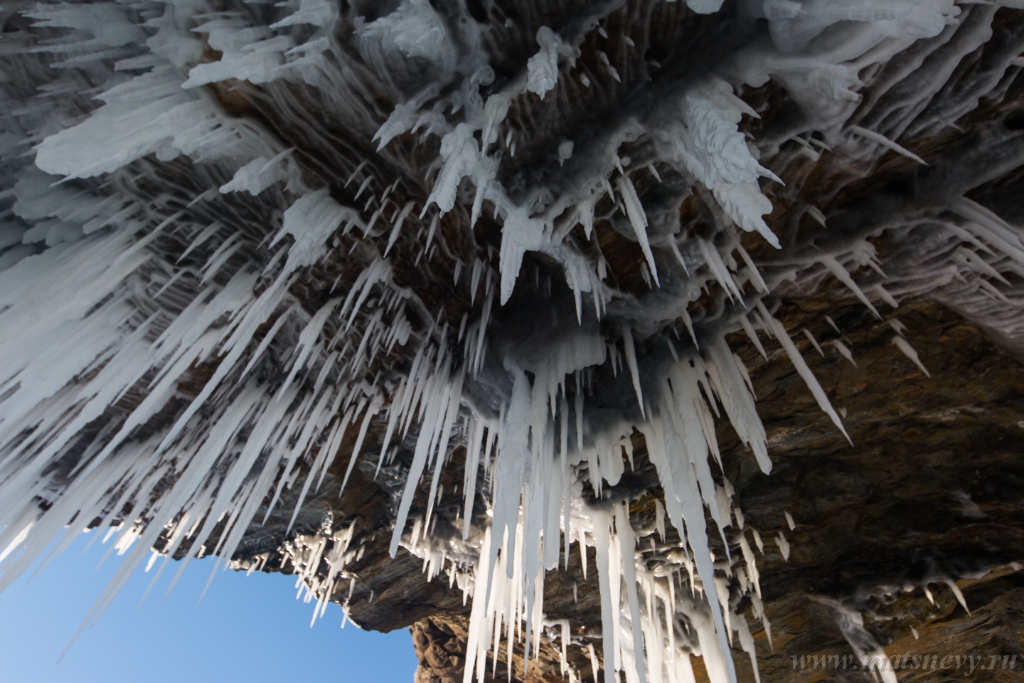 D04B8974.JPG - The rock on the frozen lake Baikal is covered with a thick layer of blue ice: many icicles and splashes