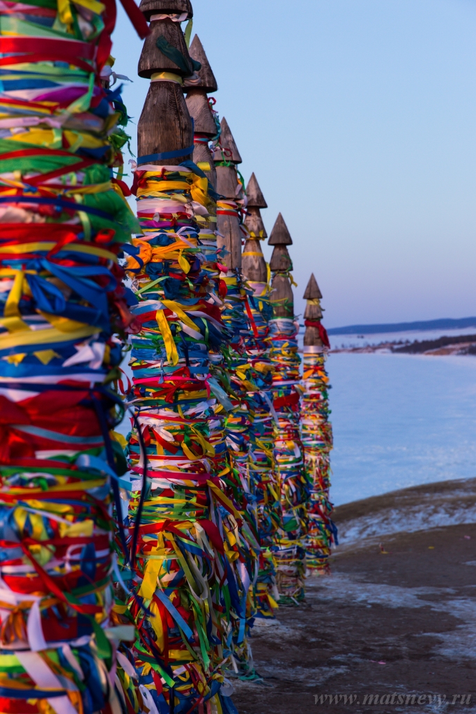 D04B9001.JPG - Colored ritual ribbons tied on the tree and wooden poles as a buddhist tradition on Baikal lake.